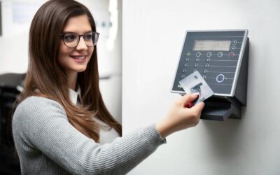 Une femme souriante utilise un lecteur de carte pour accéder en toute sécurité à son bureau.