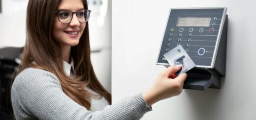 Une femme souriante utilise un lecteur de carte pour accéder en toute sécurité à son bureau.