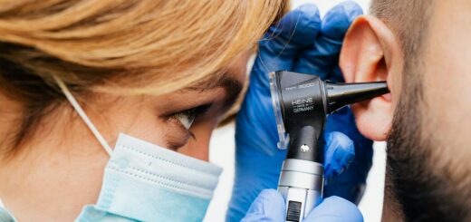 Gros plan d'un médecin effectuant un examen de l'oreille avec un otoscope.